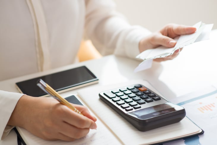 closeup-person-holding-bills-calculating-them