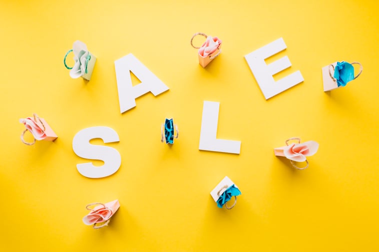 white-sale-alphabet-surrounded-with-miniature-shopping-bags-yellow-backdrop